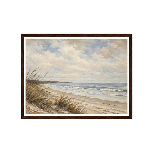 Beach grasses on sandy dunes beside gentle waves under a cloudy blue sky in a dark wood frame.