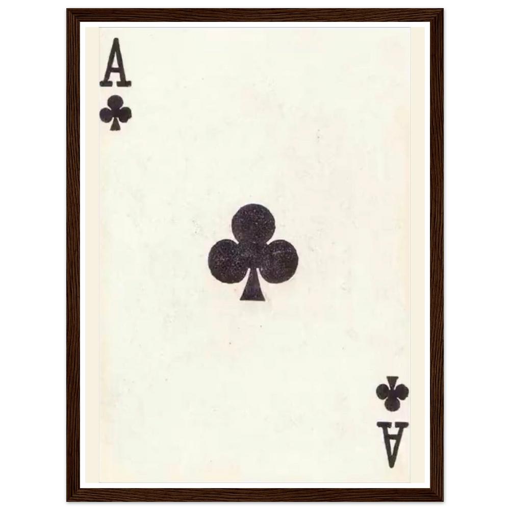 Black ace of clubs playing card on an aged cream background in a dark wood frame.