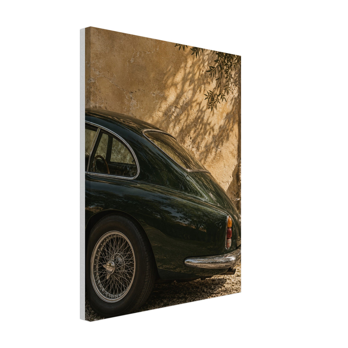 Deep green classic car beside a sunlit ochre wall with leafy shadows printed on canvas.