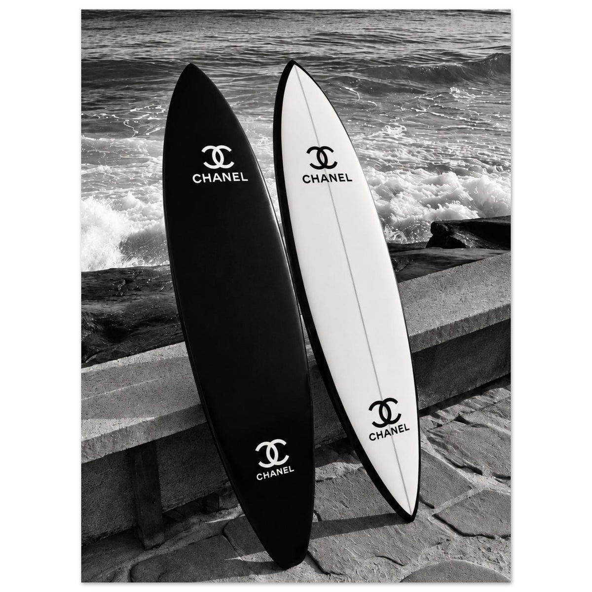 Black and white surfboards leaning against a sea wall beside the waves as an unframed poster.