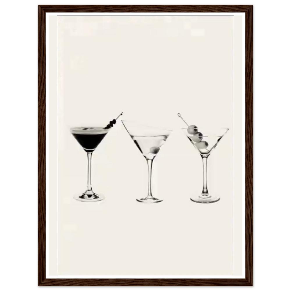 Three martini glasses with cocktail garnishes on a cream background in a dark wood frame.