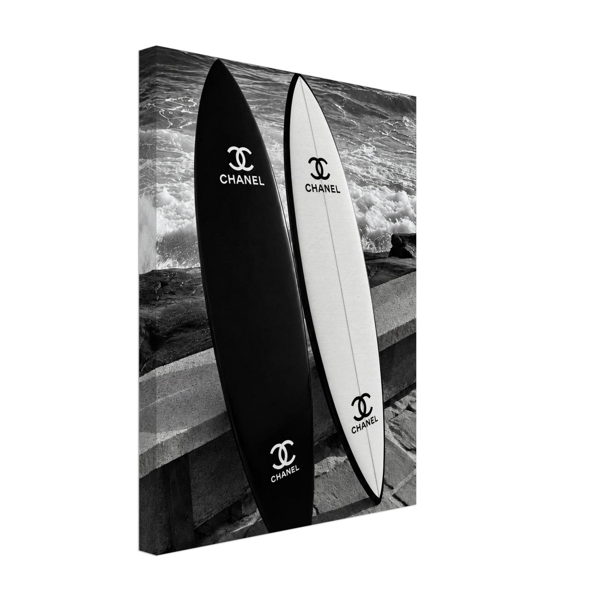 Black and white surfboards leaning against a sea wall beside the waves printed on canvas.